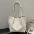 Minimalistische weiße Leder-Shopper mit Webstruktur und langen Henkeln in Lifestyle-Szene - Weiß