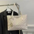 Chic cream tote bag with dark grey M-print pattern and golden logo charm detail - White
