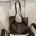 Grand sac cabas tressé marron foncé avec détail de nœud sur une chaise moderne - Marron