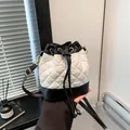Elegante bolso de cubo acolchado en blanco y negro con cordón y detalles dorados - Negro
