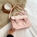 Pink textured crossbody Cambridge bag with decorative buckles and top handle design - Pink