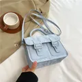 Light blue crossbody satchel featuring unique crinkled marble texture and dual buckles - Blue