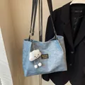 Hellblaue Denim-Tragetasche mit Plüschwolken-Anhänger und schwarzen Schultergurten - Mit Anhänger / Blau