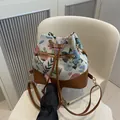 Floral embroidery bucket bag with brown leather trim and metal zipper detail - Brown