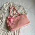Bolso tote rosa rectangular con lazo de cuadros y detalle de logo sobre vestido casual - Rosa