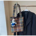 Detail of vintage plaid woven bucket bag featuring a cute white plush puppy charm - With Pendant / Brown
