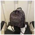 Detailansicht des Mini-Rucksacks mit Leopardenmuster, Plüschtextur und Lederpaspeln - Schwarz