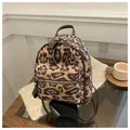 Detail eines trendigen Mini-Rucksacks mit Leopardenmuster, Vordertasche und braunen Ledergriffen - Khaki