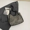 Grand sac cabas rétro vert-gris avec bandoulières en cuir noir sur bureau minimaliste - Brun Foncé