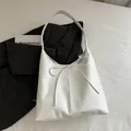 Minimalist white leather tote bag with bow detail, shown with business blazer - White
