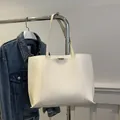 Minimalist white leather tote bag with small rectangular metal buckle and thin shoulder strap - White