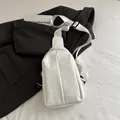 Bolso bandolera blanco minimalista con correa ajustable sobre un traje negro elegante - Blanco