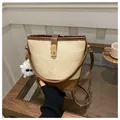 Retro canvas bucket bag with brown leather trim and golden lock in a cafe setting - With Pendant / Brown