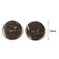Detail view of 15mm brown coconut wood buttons with two holes and natural textures - 15mm (100 Pieces Pack) / Brown