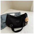 Detail of black crescent crossbody bag with Fashion logo and plush eye charm on denim - Black With Pendant