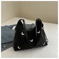 Detail of black tote bag featuring silver butterfly buckles and nylon pleated texture - Black