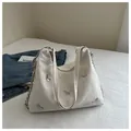 Detail of white wrinkled leather shoulder bag featuring silver 3D metal butterfly charms - White