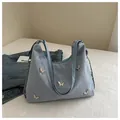 Detail of light blue hobo bag with silver butterfly charms and metal chain strap - Blue