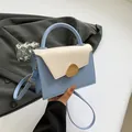 Minimalist light blue and cream crossbody bag with a gold organic buckle and top handle - Blue