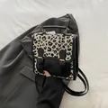 Petit sac à dos chic pour femme à motif léopard avec boucles dorées et poignée haute - Noir