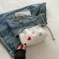 White corduroy drawstring crossbody bag with colorful heart patches and silver chain strap - White