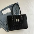 Glossy black butterfly tote bag with crinkle texture and silver metallic charm - Black