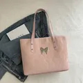 Pink pleated tote bag for women featuring a silver butterfly charm and slim shoulder straps - Pink