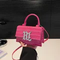 Rosa Handtasche mit Krokodilprägung, silbernem M-Buchstaben und Schultergurt - Rosarot