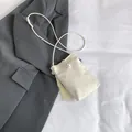 Mini-Handyumhängetasche aus cremefarbenem Leder mit Perle und Quastenanhänger - Weiß