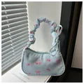 Détail d'un sac à main bleu clair avec motifs de roses et poignée à effet froncé - Bleu