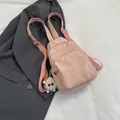 Pink pleated crossbody bag with plush charm on a grey blazer background - With Pendant / Pink