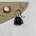 Classic black quilted bucket bag with golden chain strap and drawstring closure - Black