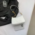 White glossy baguette shoulder bag with butterfly embossed texture and gold chain strap - White