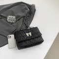 Chic black quilted shoulder bag with silver bow buckle and leather chain strap - Black