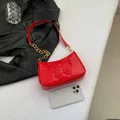 Glossy red shoulder bag with butterfly embossing and gold chain strap detail - Red