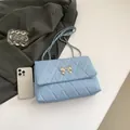 Light blue quilted crossbody bag with silver bow buckle and elegant chain strap - Blue