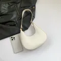 Minimalist white crescent shoulder bag in fine leather finish with gold hardware details - White