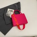 Rose red tote bag with a geometric wide shoulder strap on a grey blazer backdrop - Rose Red