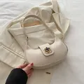 Chic cream-white crescent hobo bag featuring a decorative golden floral buckle - White