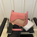 Detalle de bolso bandolera de retazos rosa y beige con cadena dorada y solapa ondulada - Rosa intenso