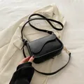 Elegante borsa a tracolla nera con patta curva e dettagli a catena raffinati - Nero