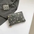 Dark grey canvas clutch with beige floral embroidery and gold zipper detail - Black