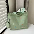Minimalist light green canvas tote bag with colorful embroidery and matching coin purse - Green
