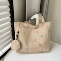 Beige canvas tote bag with colorful letter embroidery and matching mini round pouch - Khaki