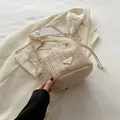 Chic cream-colored straw bucket bag with contrasting chain strap and drawstring closure - With Pendant / White