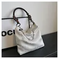 Dettaglio ricamo floreale su borsa in seta bianco crema con manico in legno - Argento