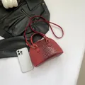Mini sac coquille bordeaux à motif crocodile avec poignées et bandoulière dorée - Rouge