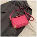 Magenta crossbody bag in synthetic leather featuring embossed letters and a gold clasp - Pink