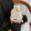Mini cream drawstring bucket bag with elegant pearl handle and gold chain strap - White