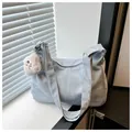 Detail of soft light blue tote bag with fuzzy dog charm against shuttered window - With Pendant / Blue